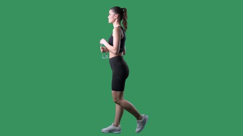 Side view of active fit young woman refreshing drinking water. Full body on chroma key green screen.