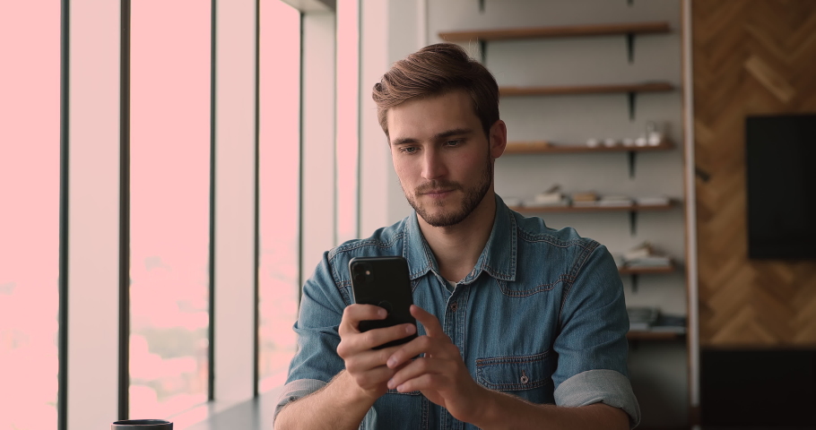 Happy millennial 30s man looking at smartphone screen, feeling overjoyed excited of getting online lottery win notification, celebrating gambling or profitable mobile auction bid, internet success. Royalty-Free Stock Footage #1066904992