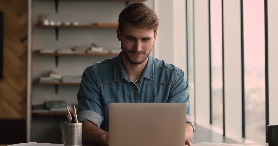 Focused young motivated man working on computer at home or office, stuck with difficult ask, thinking on problem solution, analyzing statistics data preparing electronic report, using software app. Royalty-Free Stock Footage #1066905073