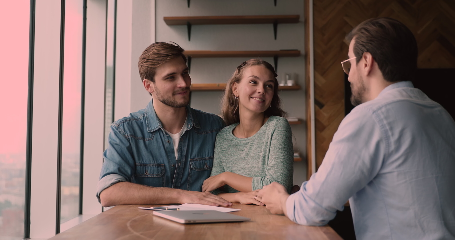 Smiling bonding caucasian family couple taking professional consultation from realtor, making decision of buying own apartment, signing agreement at office meeting, getting keys from own dwelling. Royalty-Free Stock Footage #1066905181