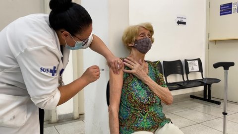 Sao Paulo, SP, Brazil - February 5, 2021: A nurse gives a shot of COVID-19 CoronaVac vaccine to an elderly woman during a priority vaccination program for people with more than 90 years old.