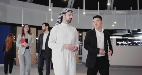 Arabic Businessman and Chinese Executive Meeting in Corporate ocridor Heading to Office Meeting Boardroom negotiating. Communication Concept.