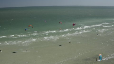 Drone view on the beach with lots of kites, high angle view, summer vacation, 4k. Summer Fun Action Sports. Colorful kites all over the beach on a sunny day. Lots of tents on the beach and kites