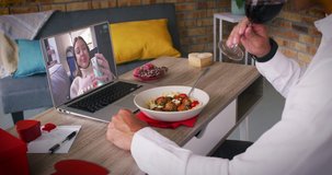 Caucasian couple on a valentines date video call woman on laptop screen laughing man eating meal. online valentines day during quarantine lockdown.