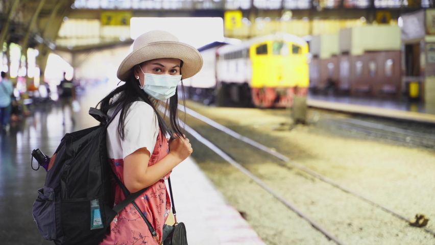 Travel video Woman tourists stand waiting for the metro at the station. At the train station,Woman wearing a mask and carrying her luggage waited for the train to enter the platform,4K Res | Shutterstock HD Video #1066940257