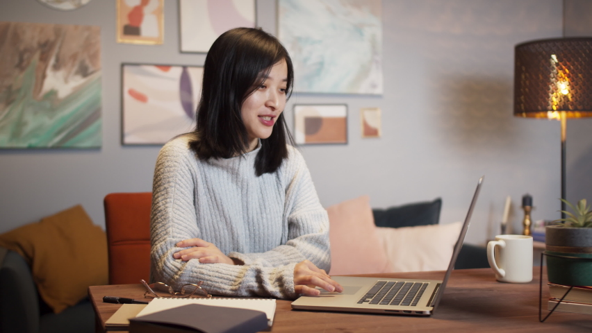 Asian woman using laptop during video conference call. Remote learning during coronavirus lockdown, happy Korean female chat with family and friends home isolation, living room, freelancer home office | Shutterstock HD Video #1066943002