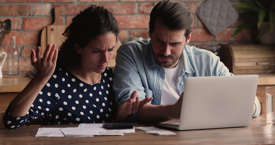 Spouses experiencing financial problem, concerned wife and husband examining family budget feel stressed due high taxes, lack of money to pay monthly household bills, bank loan, unpaid receipt concept | Shutterstock HD Video #1066944841