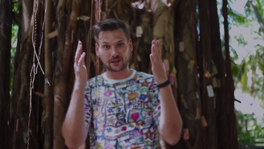 An emotional blogger tells something to the camera in sunny weather in the Maldives.