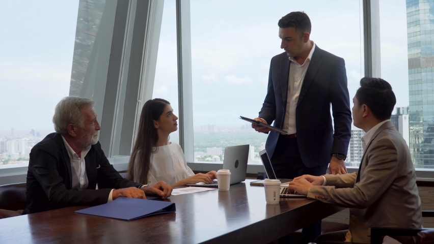 Group of business People Meeting  in office on window . marketing team Conference Brainstorming. manager man standing and present . Financial Teamwork discussing strategy at workspace on cityscape  | Shutterstock HD Video #1066950496