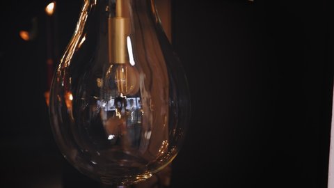 turning on, off the lamp, chandelier. close-up. bulb with Edison filament. incandescent lamp. the vintage style lamp bulb with Edison filament is switching off and on.