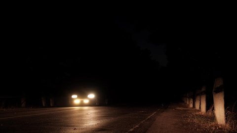 The headlights of the car are shining. Car on the road at night.