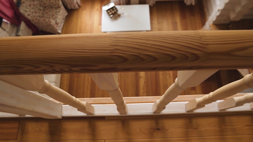 A girl in a beautiful white dress walks through the living room of a beautiful wooden house. Shooting from above in motion