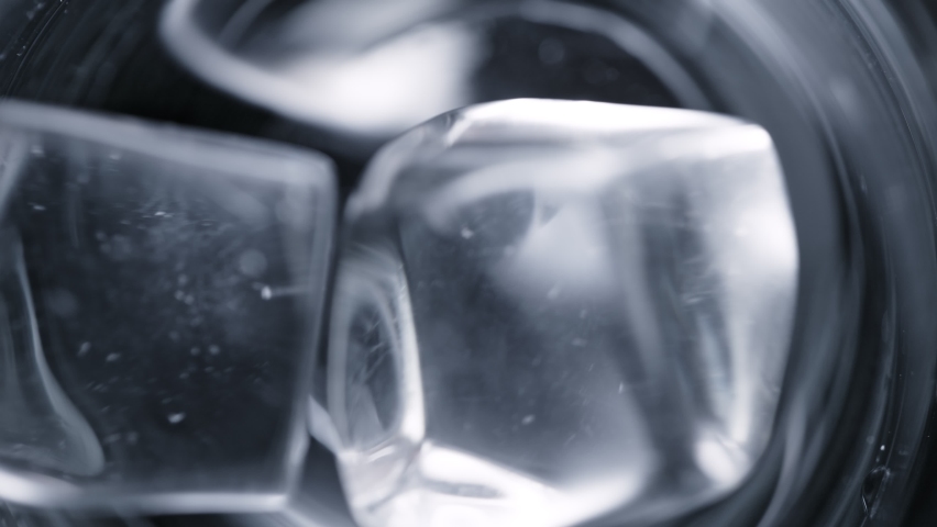 Super Slow Motion Detail Shot of Ice Cubes Falling into Glass With Alcohol Liquid at 1000 fps. Royalty-Free Stock Footage #1066966912