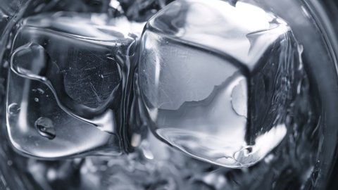 Super Slow Motion Detail Shot of Ice Cubes Falling into Glass With Alcohol Liquid at 1000 fps.