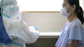video of Asian doctor or nurse wearing ppe suit and face mask in hospital with an injection vaccine for covid-19 or corona virus patient. Corona virus, Covid-19, virus outbreak or medical mask concept