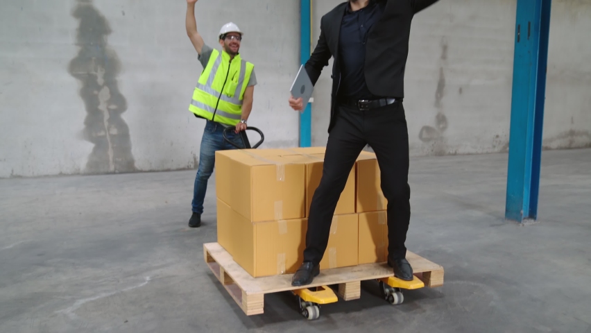 Funny factory workers dance in the factory . Happy people at work .