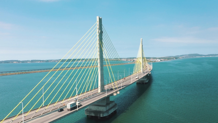 Cinematic orbital aerial shot bridge above the turquoise color ocean, located in Laguna, Santa Catarina, Brazil