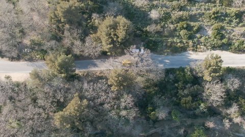 Top down drone shot of VW T4 Van driving along a road on a sunny day.