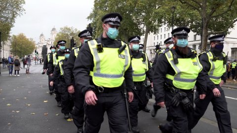 London , United Kingdom (UK) - 10 24 2020: A unit of riot police in face masks march along Whitehall