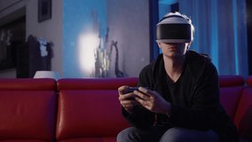 Young man playing games in the evening. Modern entertainment, esports and online fun. Virtual reality helmet, person in cyberspace.
