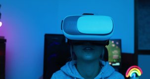 Girl gamer playing at virtual reality game online using vr headset