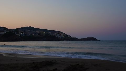 Sunset on Crete Coast. Town on the hill near the sea
