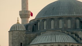 Beautiful evening long clip of the dome of Blue Mosque with Turkish flag flying from minaret.