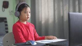 Asian child or kid girl e-learning on computer notebook to wearing headphone and sleepy yawn or bored to video call communication by study online or people learn from home by laptop to back to school