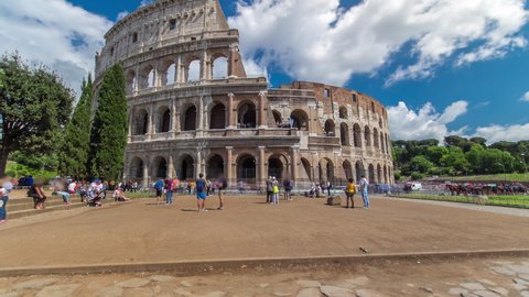 Many tourists visiting The Colosseum or Coliseum timelapse hyperlapse, also known as the Flavian Amphitheatre in Rome, Italy. Cloudy blue sky