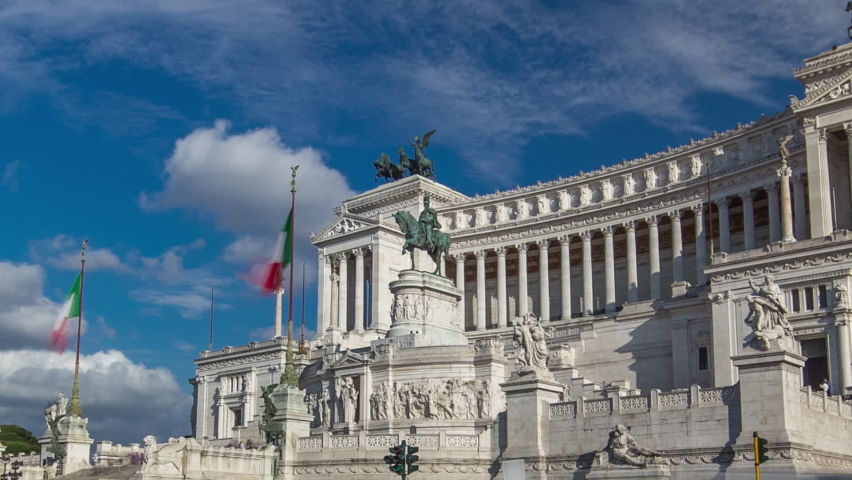 Rome, Italy. Famous Vittoriano with gigantic equestrian statue of King Vittorio Emanuele II timelapse hyperlapse. Blue cloudy sky and traffic on the road