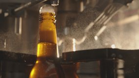 Beer filling production line. Modern glass bottle filler machine. Foam overflowing the beer bottles. Factory, brewery concept.