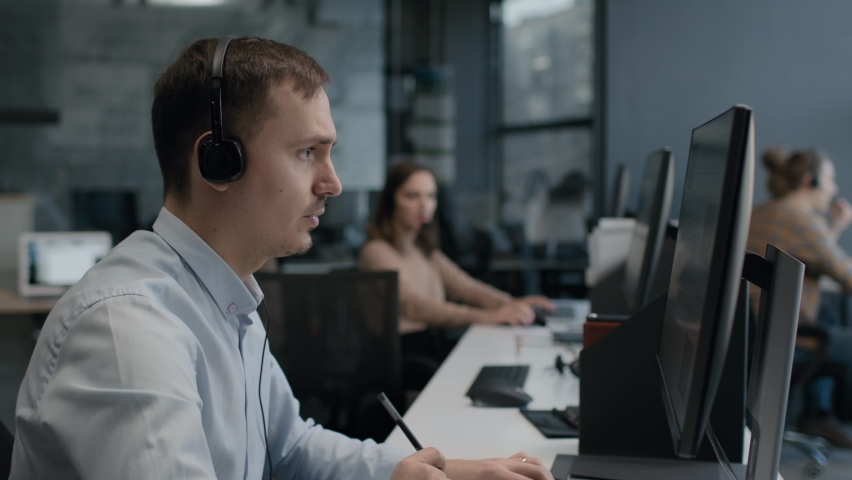 Call center and helpful customer service. Use pc computer and answer questions on phone line at modern co-working. Diverse group of people talks on sale hotline. Busy seller at agency office close-up Royalty-Free Stock Footage #1067023258