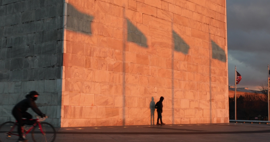 A young man looks at his own shadow on the Washington Monument, a popular tourist attraction in Washington, D.C.