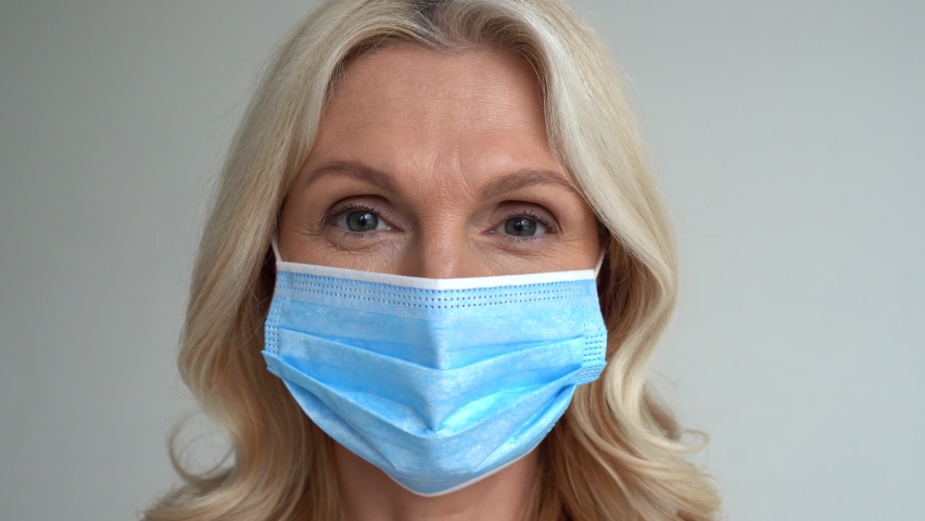 Worried 50s middle aged mature woman touching irritated sensitive face skin after wearing face mask looking at camera. Dry aging facial skin problem, allergy or acne inflammation from facemask concept Royalty-Free Stock Footage #1067038939