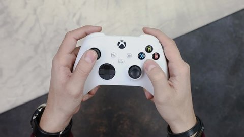 Milan, Italy - 30 January 2021: Man Holding and Playing with White Microsoft Xbox Series S Game Controller, The newest wireless gamepad, joystick for gaming