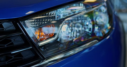 Close-up, headlight of a new blue car in a dealership, modern design. Headlight, Xenon. Bixenon. 4k, ProRes