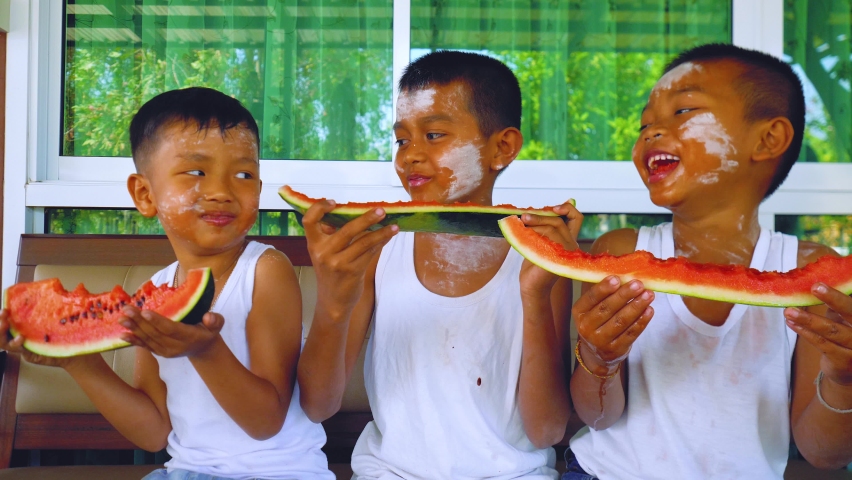 Asian boys enjoy eating watermelon together at home in summertime. | Shutterstock HD Video #1067051434