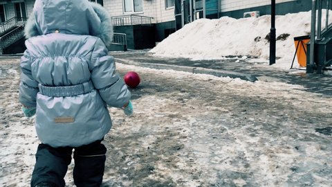 dirty snow in the yard, kid with a ball