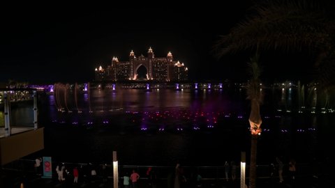 Dubai, United Arab Emirates - February 1, 2021: Music and lights fountain show with Atlantis the Palm hotel view from the Pointe waterfront dining and entertainment destination at Palm Jumeirah