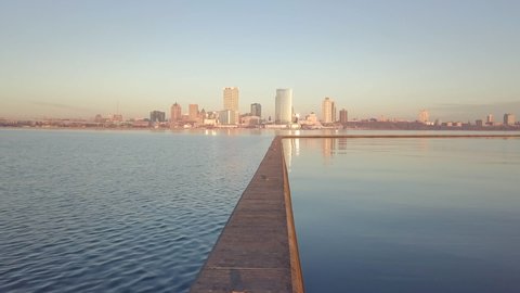 Milwaukee Wisconsin skyline during a beautiful clear sunrise with low angle perspective of Lake Michigan, establishing shot.