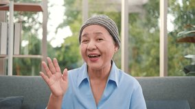 Cheerful patient older 60s Asian woman looking talking to camera conference calling at home. Smiling senior mature adult lady grandmother video chat communicate online on sofa, web cam view. - Powered by Shutterstock - Get 15% off with code: PIKWIZARD15