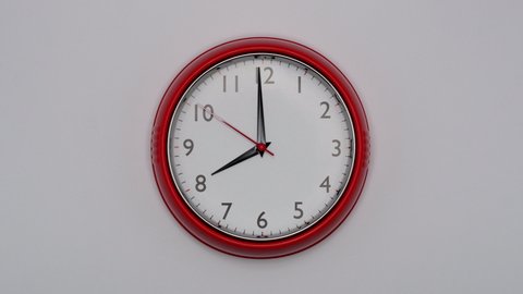 The Time Is 8.00 AM Or PM On A Red Wall Clock With A Black Arrows And Red Second Hand