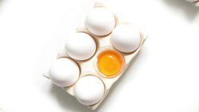 Organic white eggs and yolk in box move away on white background. 4k video