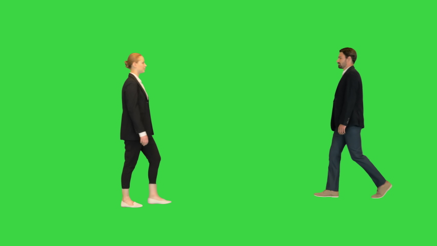 Confident business partners walking passing by each other on a Green Screen, Chroma Key.