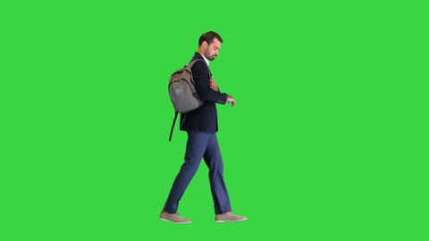 Handsome young businessman with backpack walking on a Green Screen, Chroma Key.
