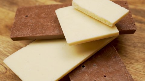 Close-up of Delicate White and Milky Porous Chocolate Bars, Rotation. The Chocolate Is Isolated. Background and Porous Delicious Chocolate.