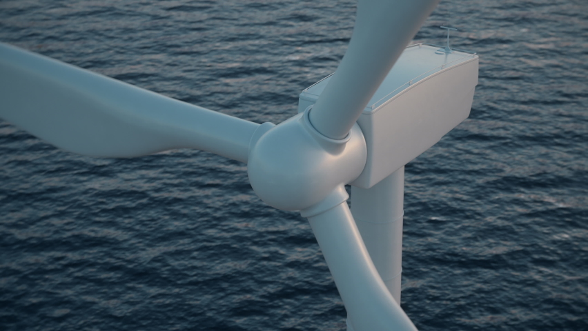 Camera moves around the head of a wind turbine to reveal an aerial view of a large wind farm in the sea against a low sun. Green and renewable energy concept. Realistic high quality 3d animation. Royalty-Free Stock Footage #1067083231