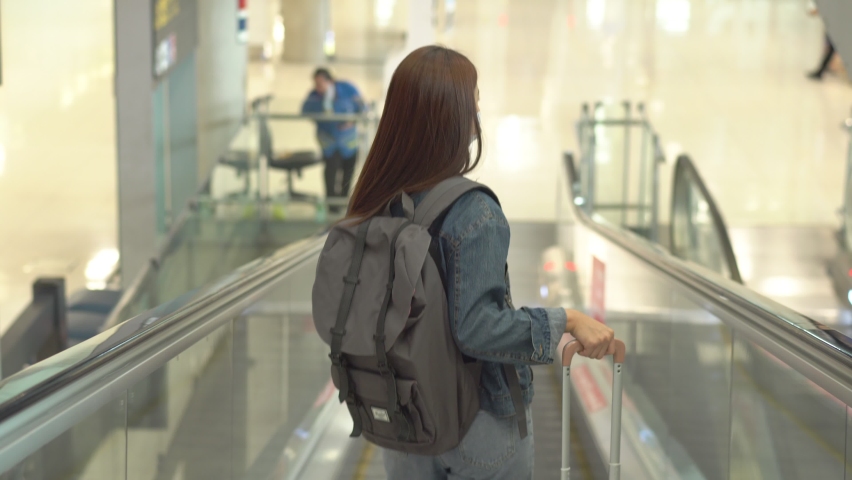 Asian tourist woman waving hand bye bye to friend of family before enter departure gate at airport terminal. people wearing protective mask during Coronavirus. new normal and social distancing Royalty-Free Stock Footage #1067083969
