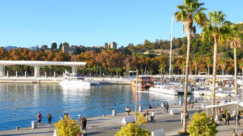 Malaga, Spain. Circa January 2021. Panorama view of the "Muelle Uno" outdoor shopping mall, the marina, main park, Pompidou museum, the port, cathedral and Alcazaba.