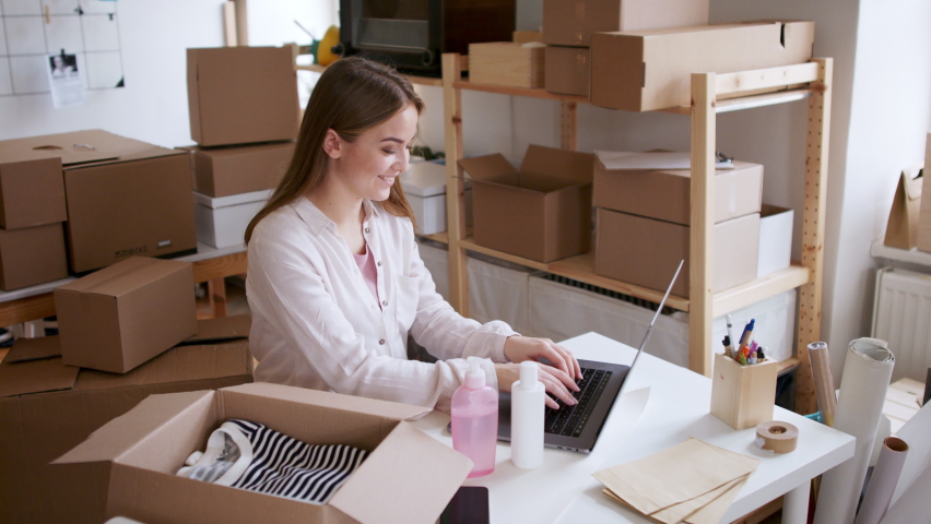 Woman dropshipper working at home and packing an order, coronavirus concept. | Shutterstock HD Video #1067085028